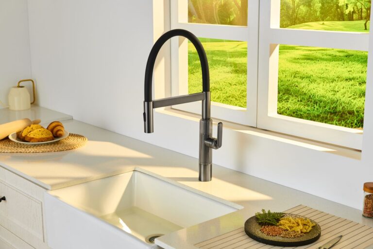 Bright kitchen interior featuring a sleek faucet, sink, and a scenic window view.